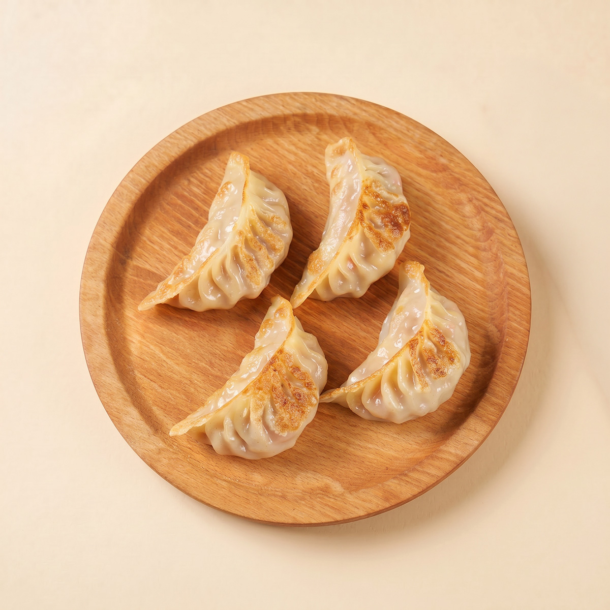 Close-up shot of crispy pre-fried sweet corn and pork gyoza showing the golden pan-fried bottom