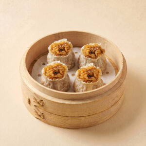 Close-up shot of steaming hot traditional Chinese sticky rice siu mai shumai showing seasoned glutinous rice filling