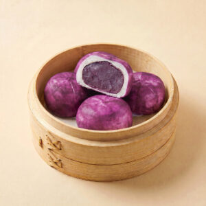 Close-up shot of steaming hot purple sweet potato steamed bao bun showing creamy sweet potato filling