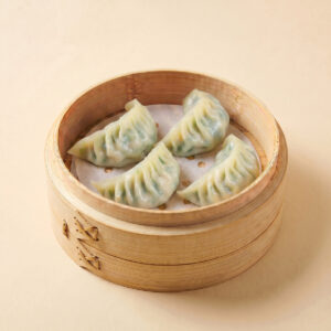 Close-up shot of boiled pork and chive dumplings sliced open showcasing fresh green chives and seasoned meat filling