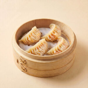 Close-up shot of boiled sweet corn and pork dumplings split open showing crisp corn kernels and savory pork filling