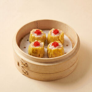 Close-up shot of steaming hot premium fish roe pork siu mai shumai topped with bright fish roe