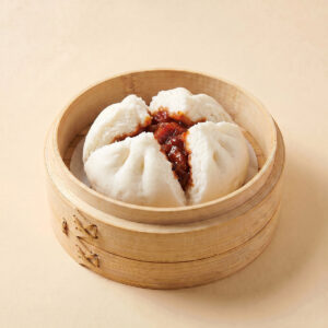 Close-up shot of a steaming hot large 130g traditional BBQ pork bun char siu bao split open